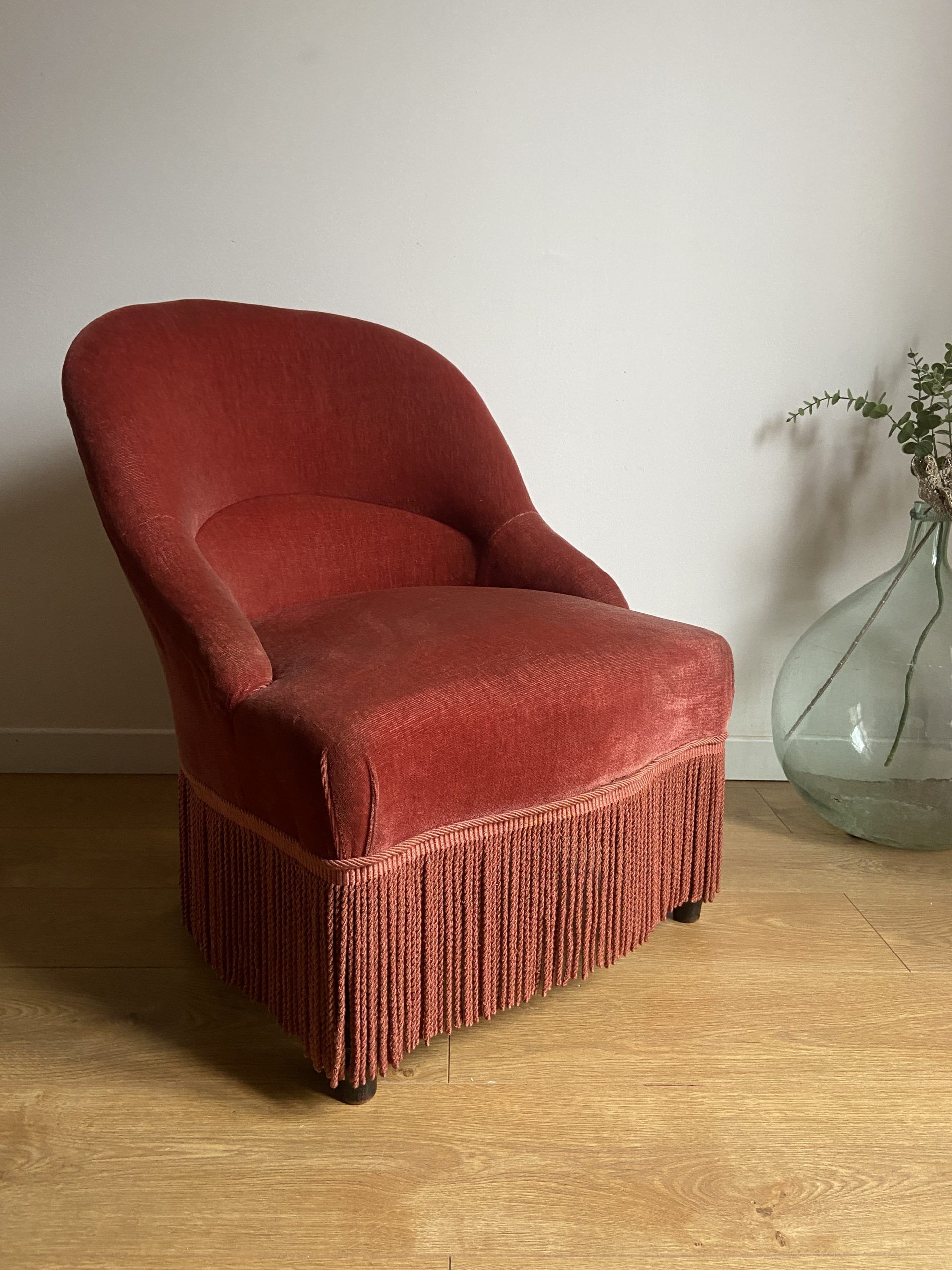 Fauteuil crapaud vintage rose framboise en velours à franges