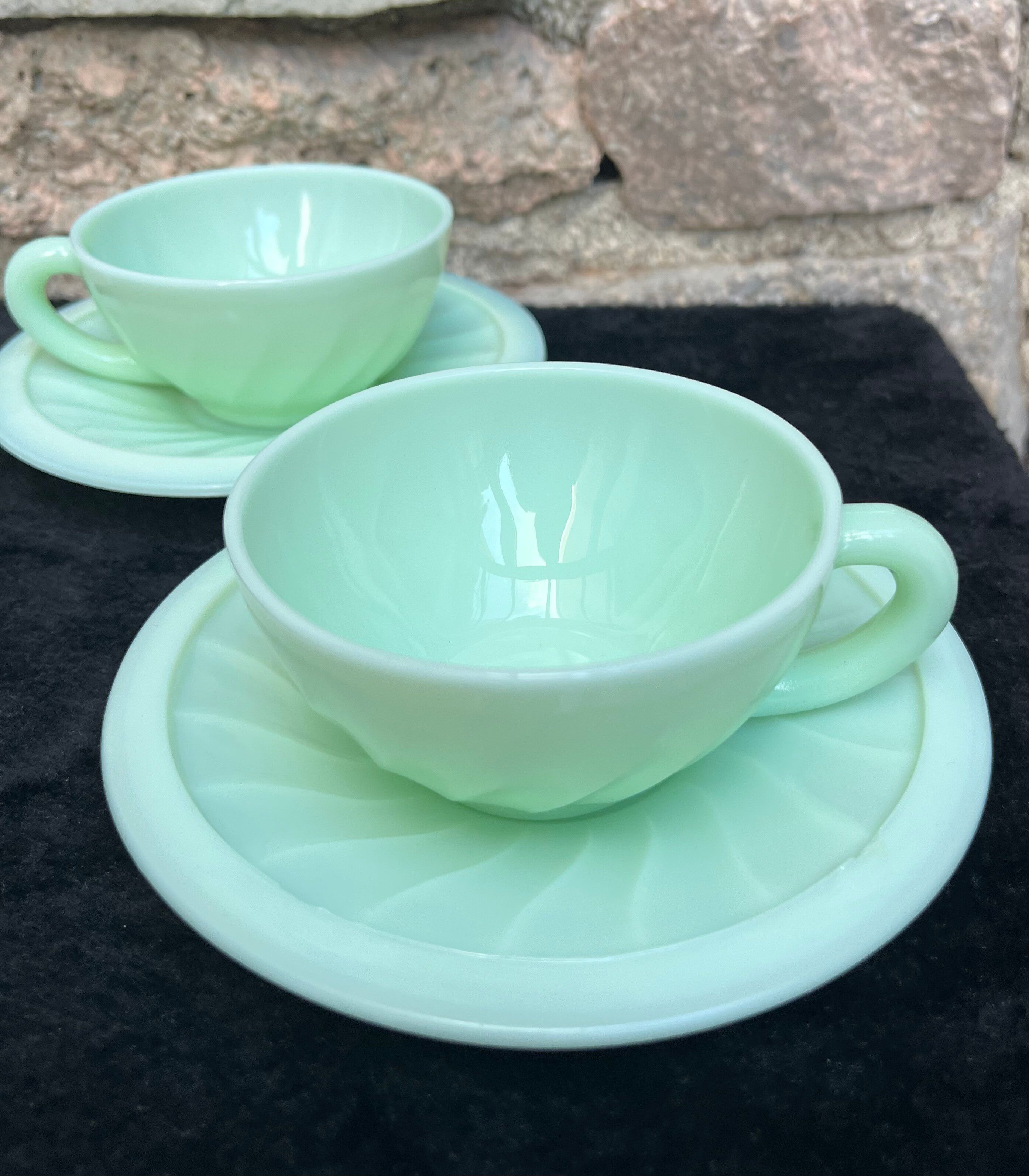 Two green opaline cup and saucer sets.