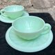 Two green opaline cup and saucer sets.