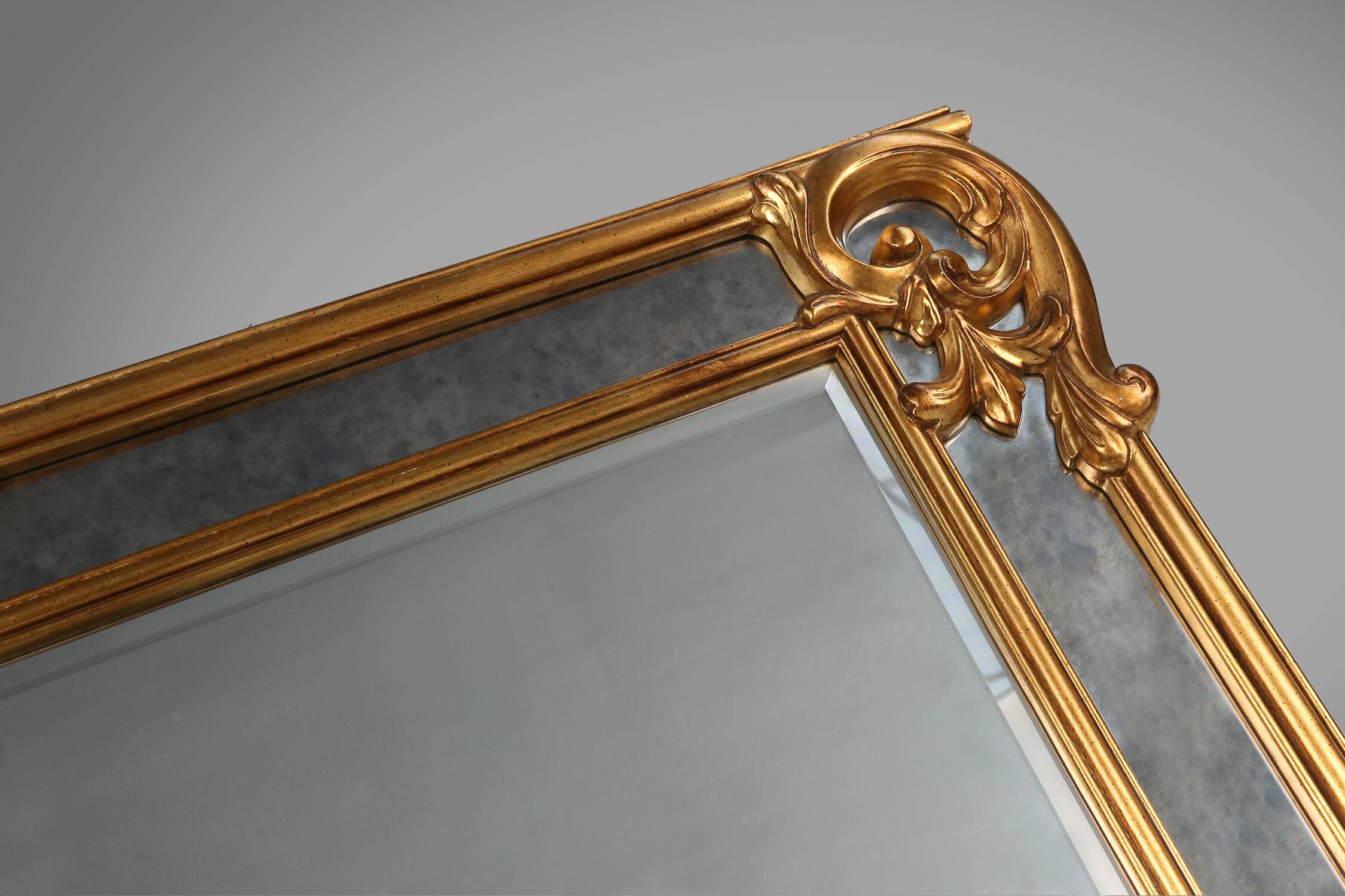 Richly decorated wall mirror in resin with golden ornaments and smoked mirror glass panels, Belgium,