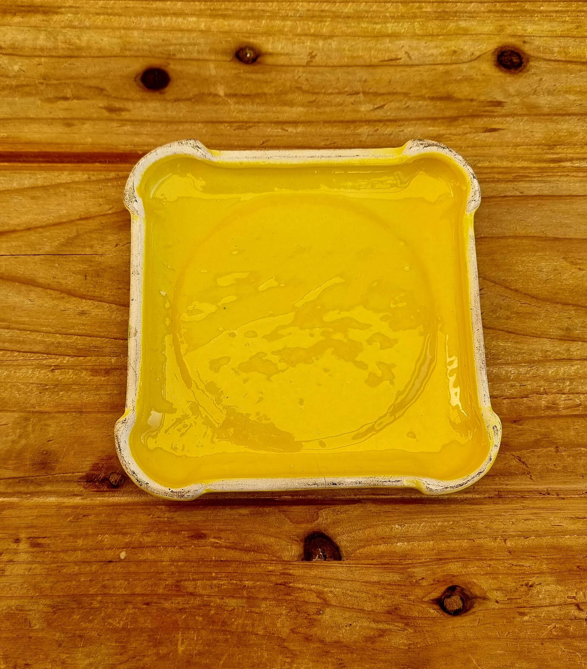 Yellow ceramic trivet and bottle coaster with vintage painted decoration.