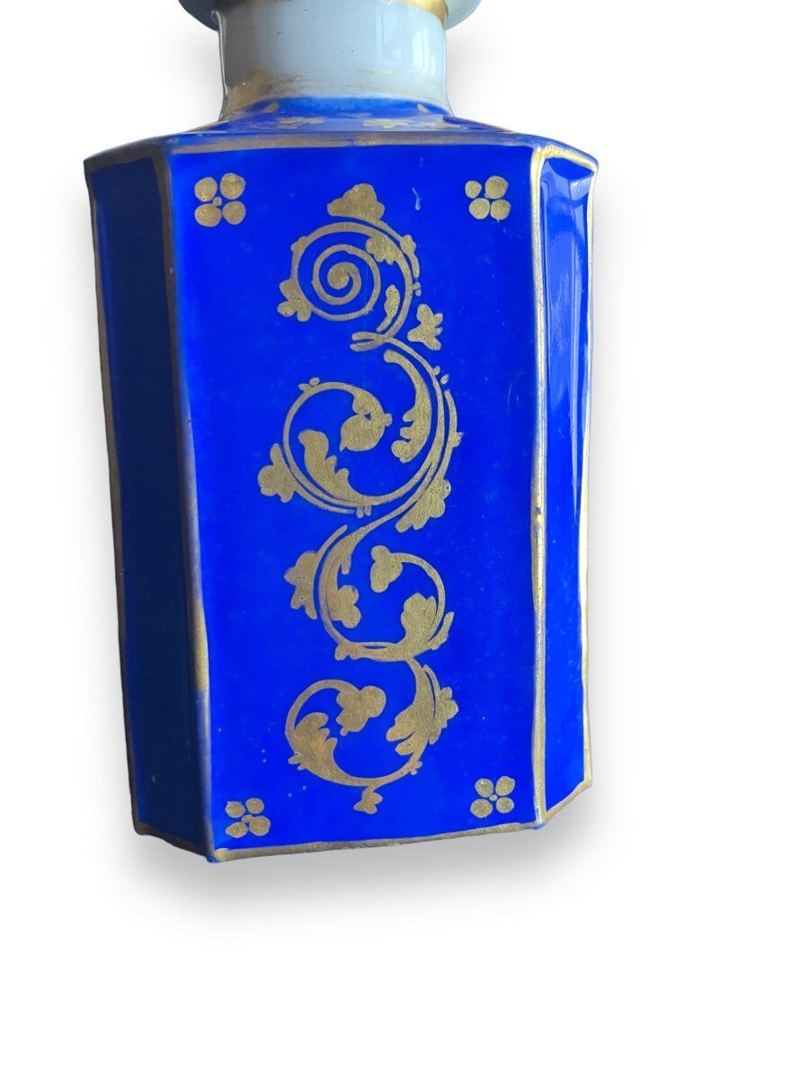 Perfume bottle in porcelain of old paris blue background