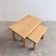Two stools or small nesting tables in light oak.