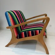 Scandinavian-style armchair in curved wood and colourful striped fabric.