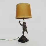 Old table lamp in repel, cherub, angel, cherub, putti with a bird in hand. 1930s