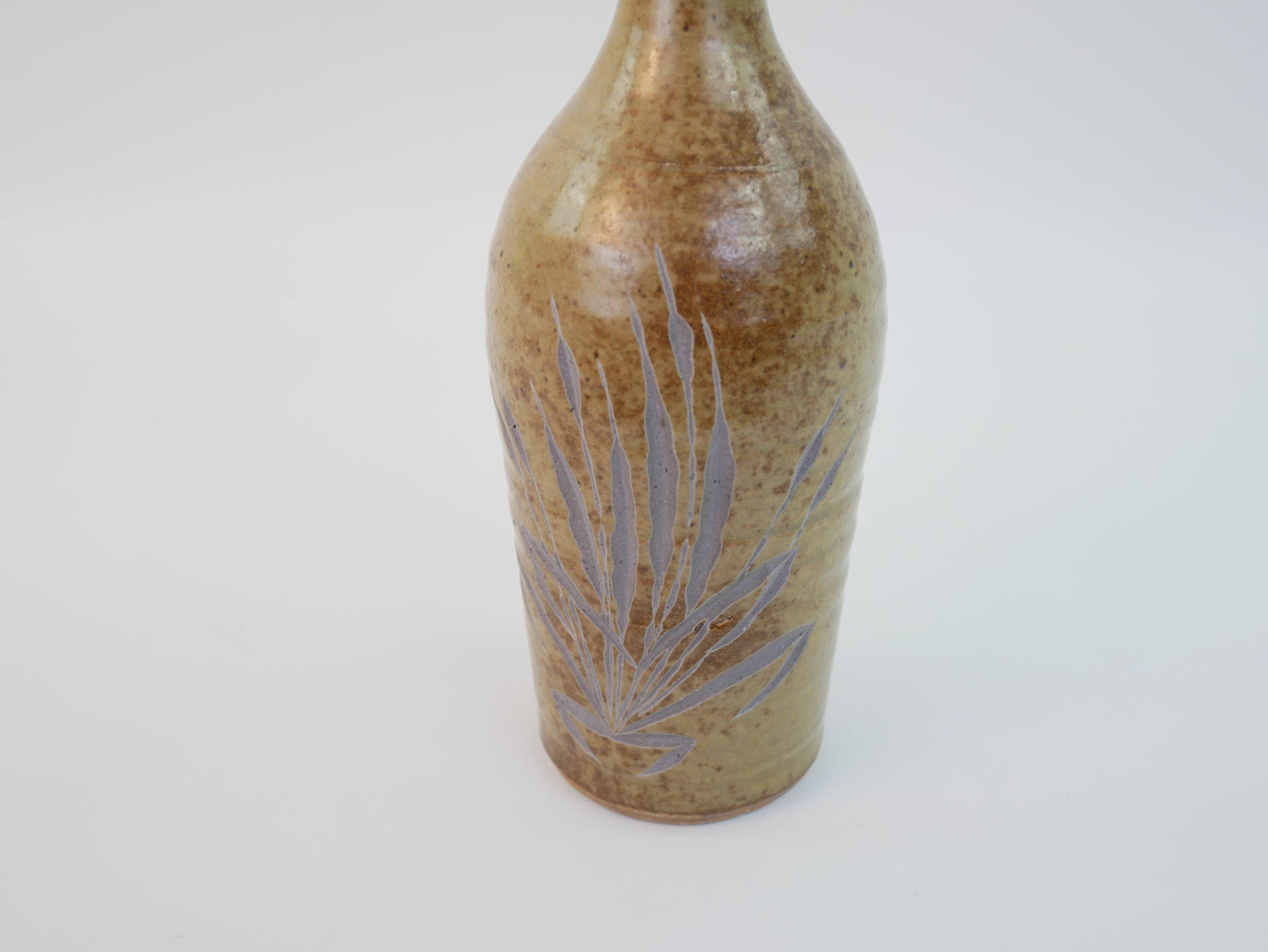 Brown ceramic/stoneware bottle with chiseled floral pattern