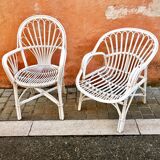 Two white rattan armchairs