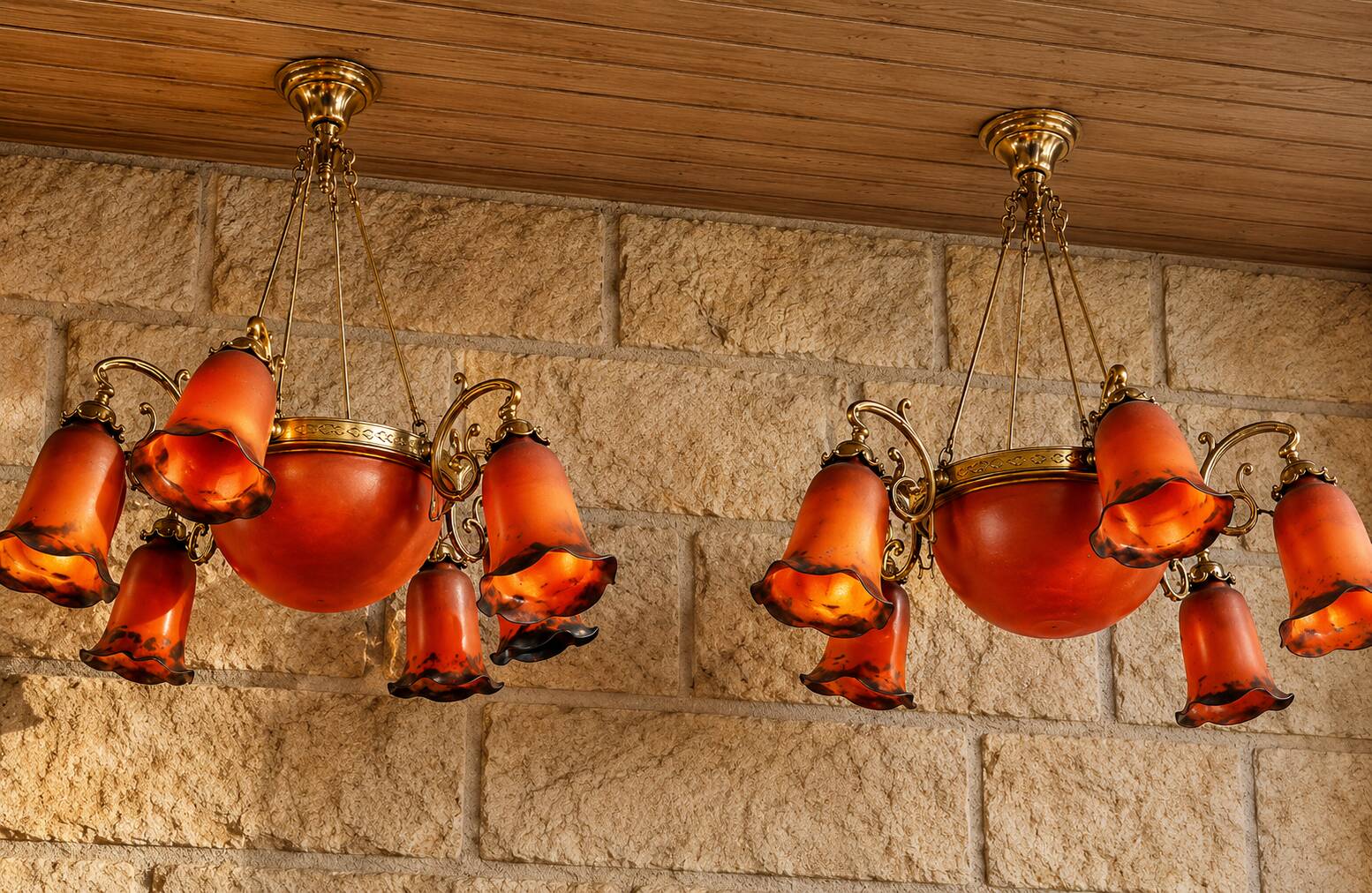 Pair of Art Nouveau style chandeliers in bronze and orange glass paste.