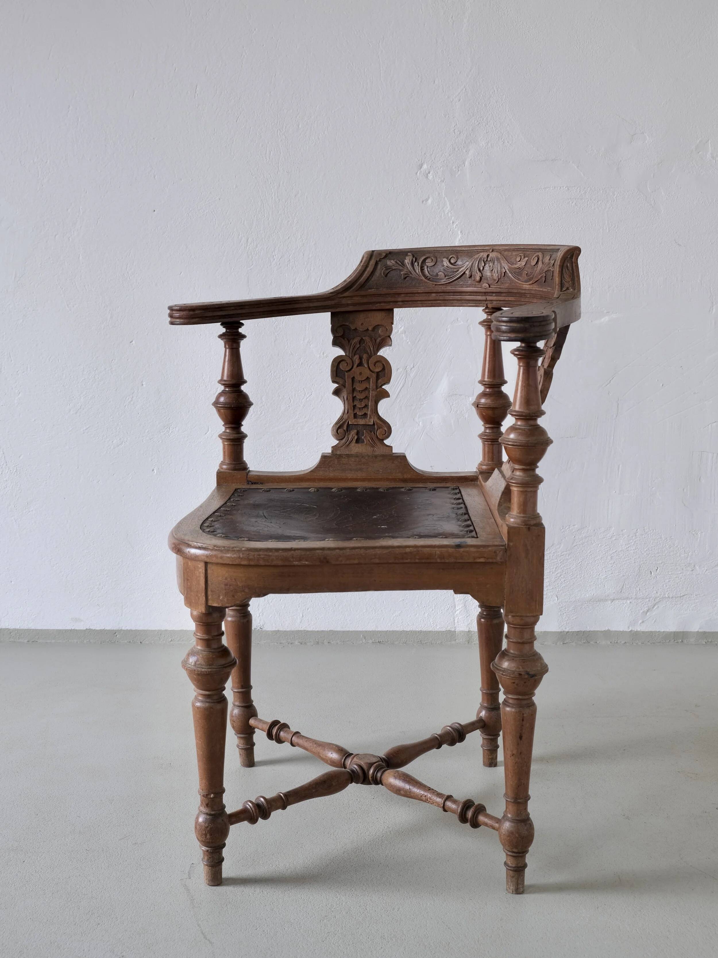 Fauteuil d'angle ancien sculpté avec assise en cuir