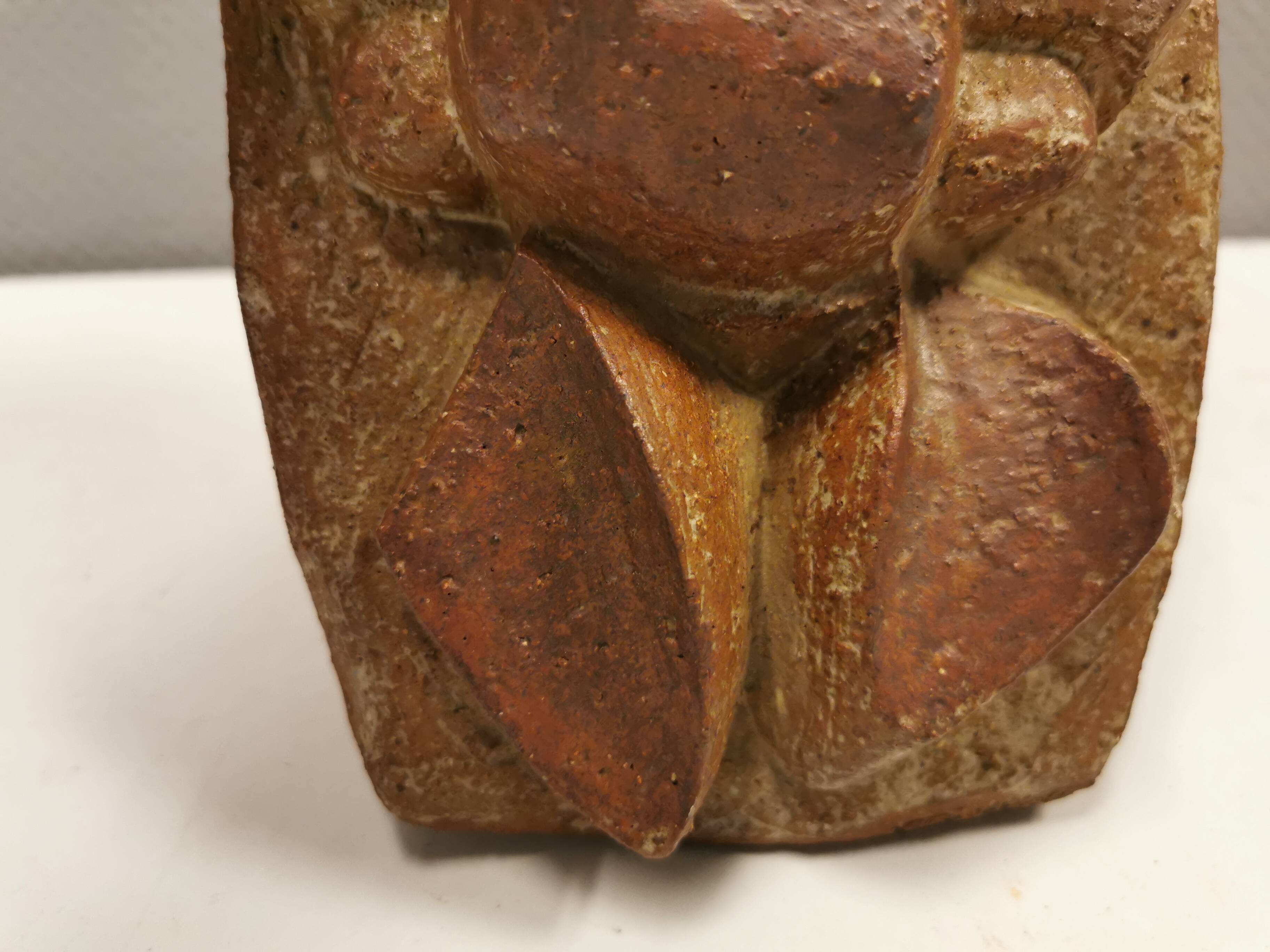 Ceramic relief portraying a lady. Emerging out of the background.