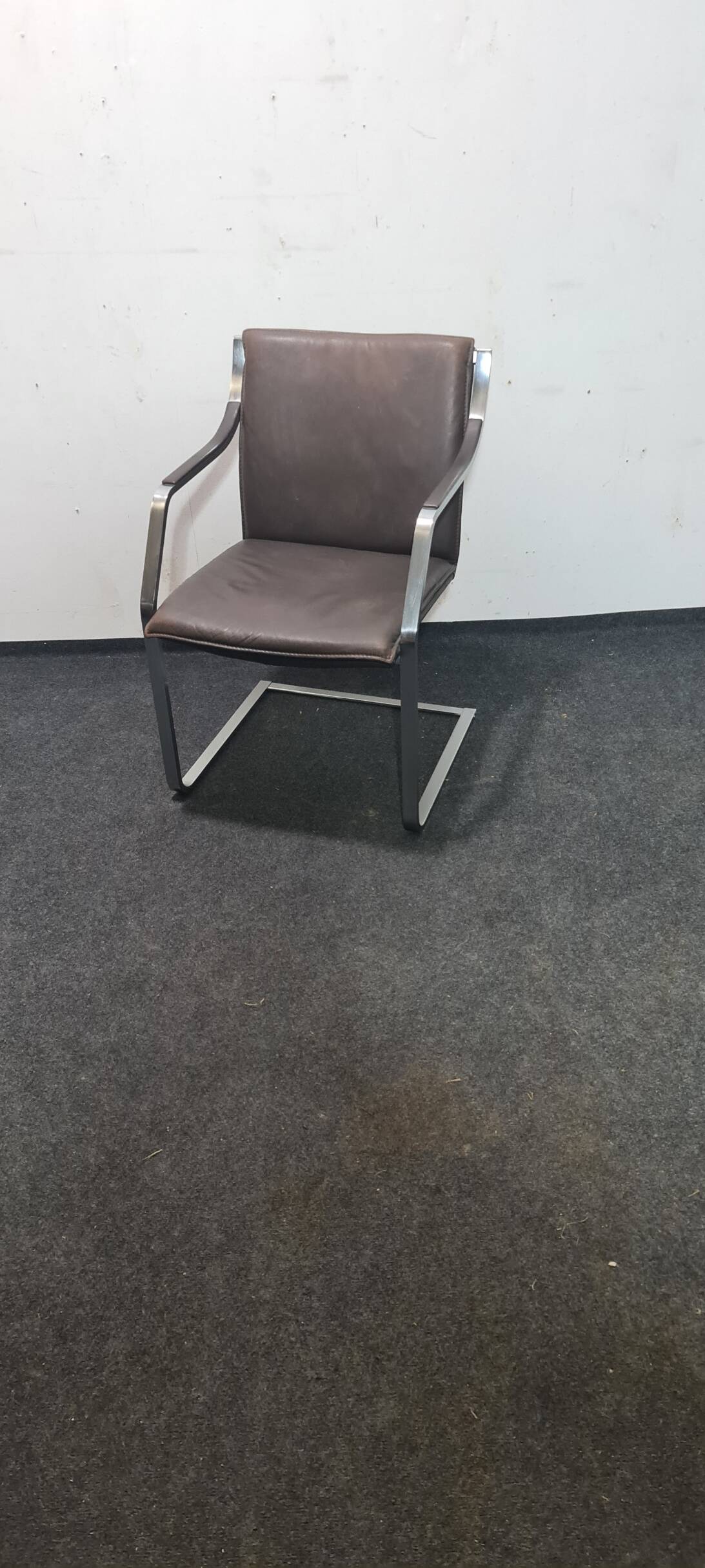 One of two vintage Leather and metal arm chairs.