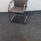 One of two vintage Leather and metal arm chairs.