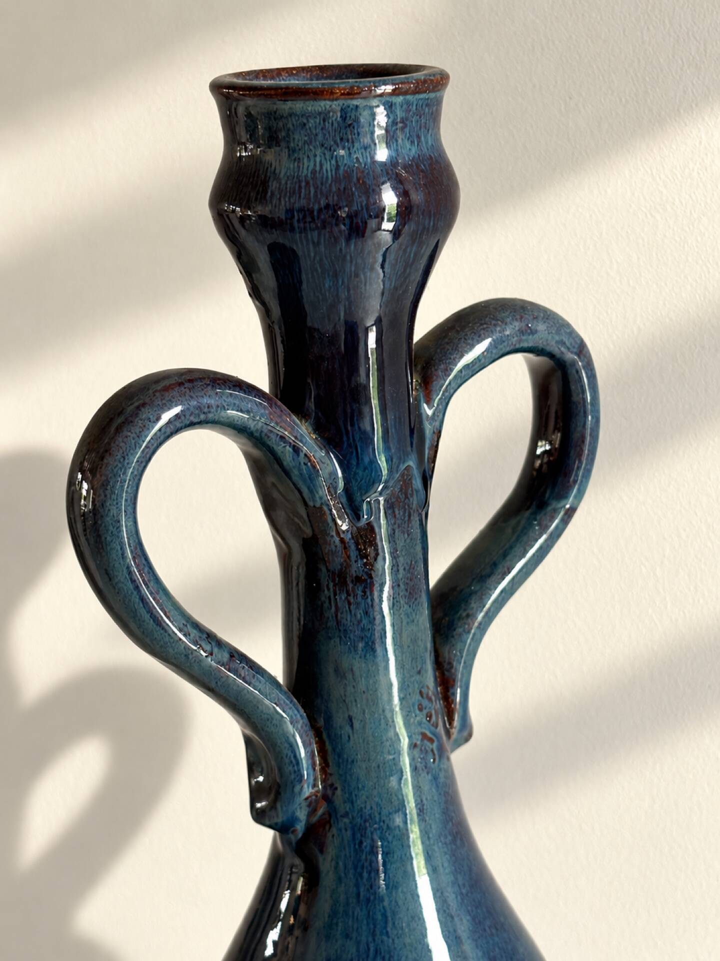 Decorative deep blue glazed ceramic vase with twin handles.