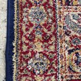 Vintage mechanical Turkish rug with box decoration on a red and navy blue background 139 x 68 cm
