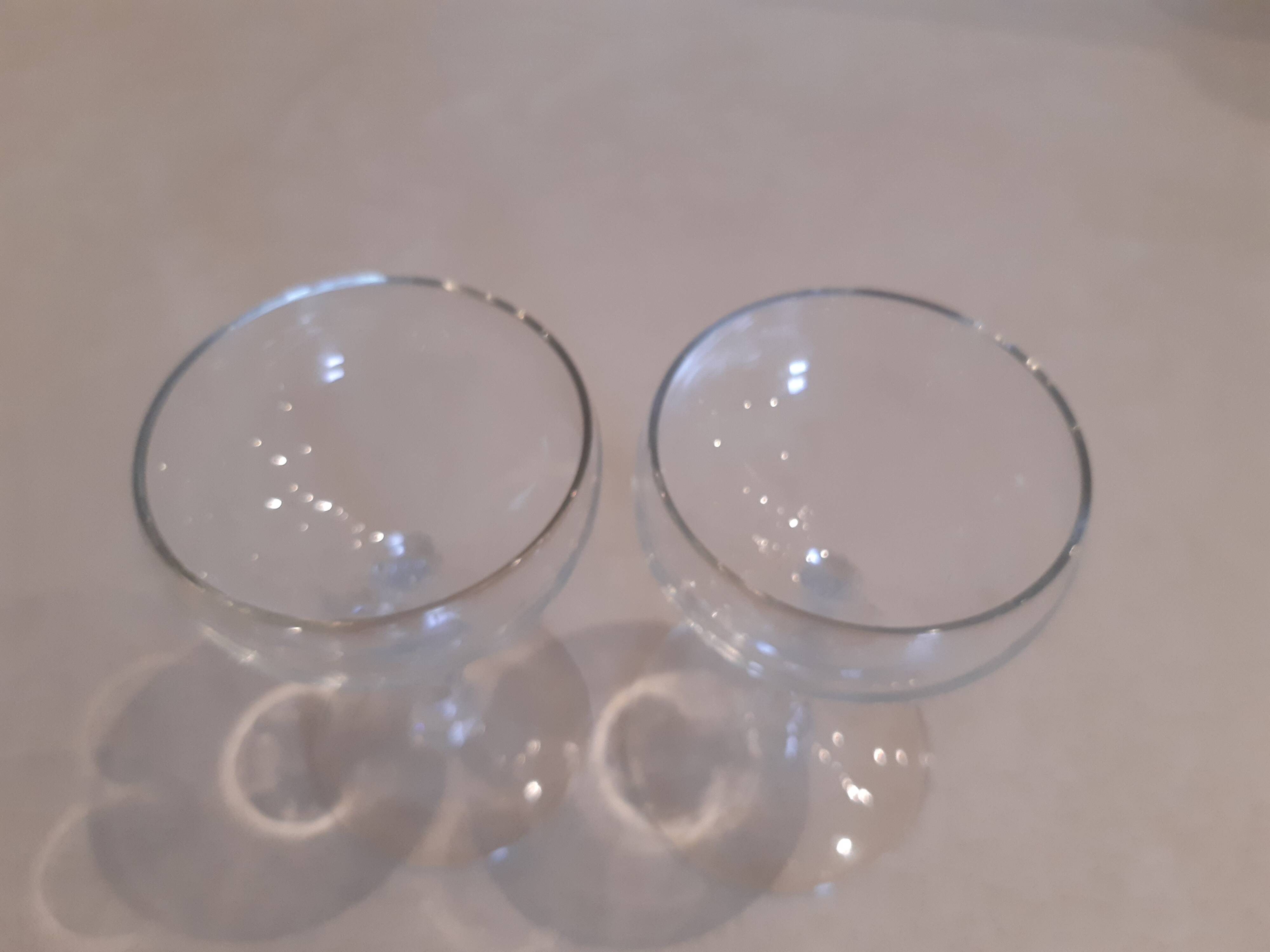 Two small crystal champagne glasses with twisted stems.