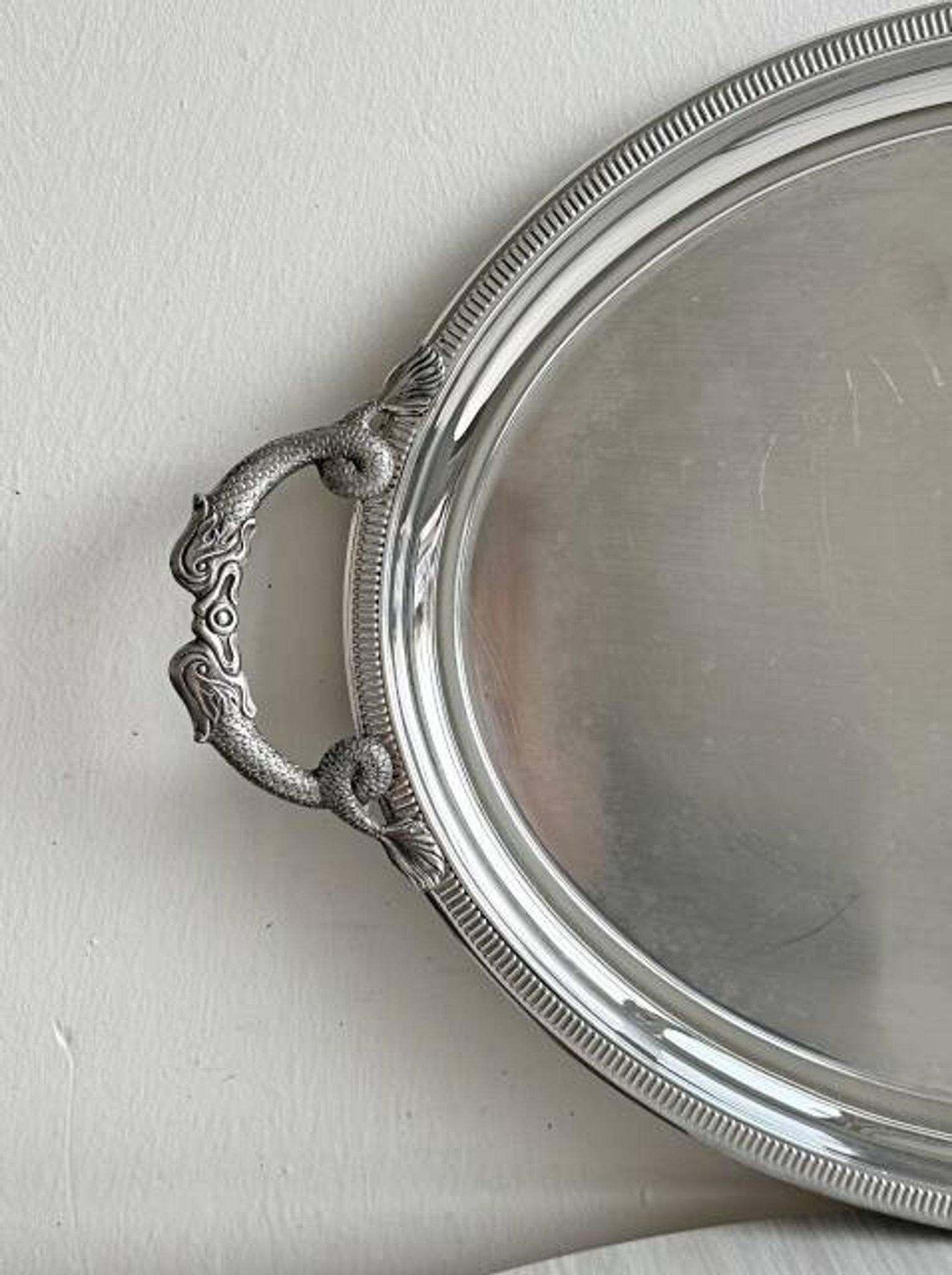 Large stainless steel serving platter with fish-shaped handles.