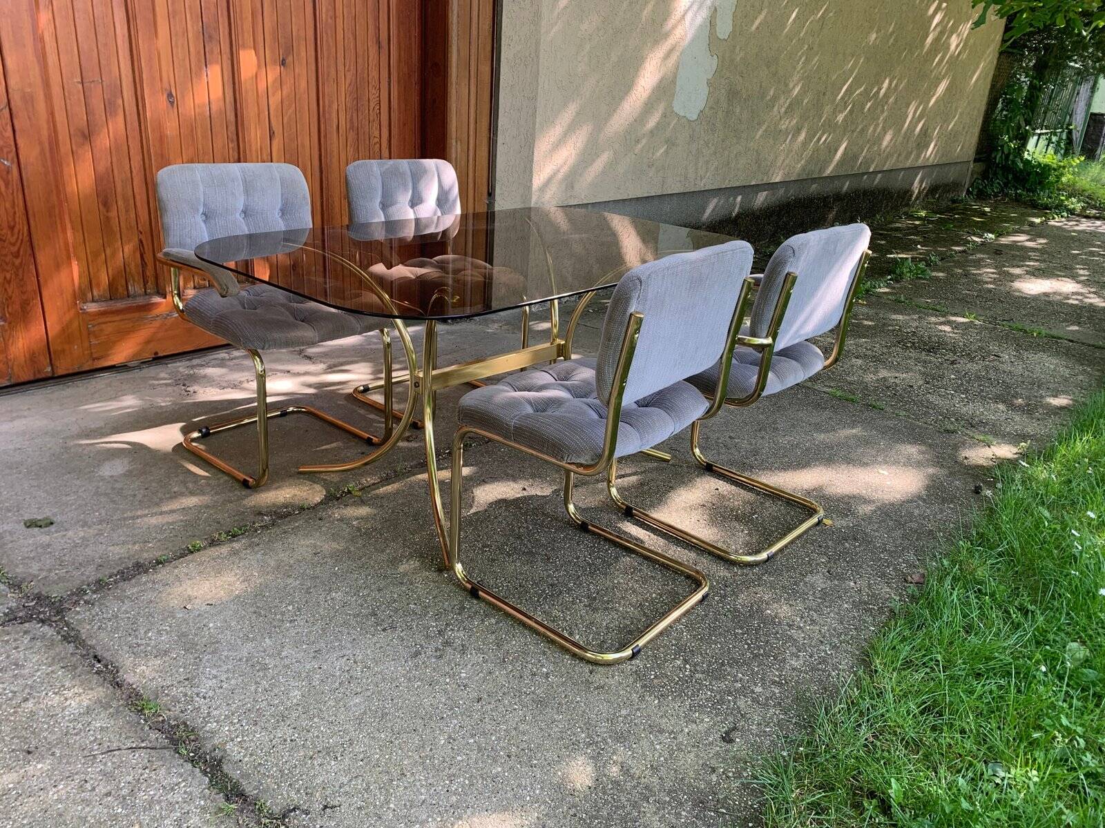 1970s table set with 4 chairs in gold brass and grey fabric, smoked glass top.