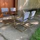 1970s table set with 4 chairs in gold brass and grey fabric, smoked glass top.
