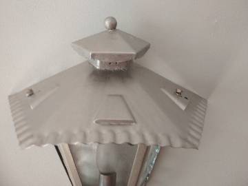 Half grey metal wall sconce and 3 windows