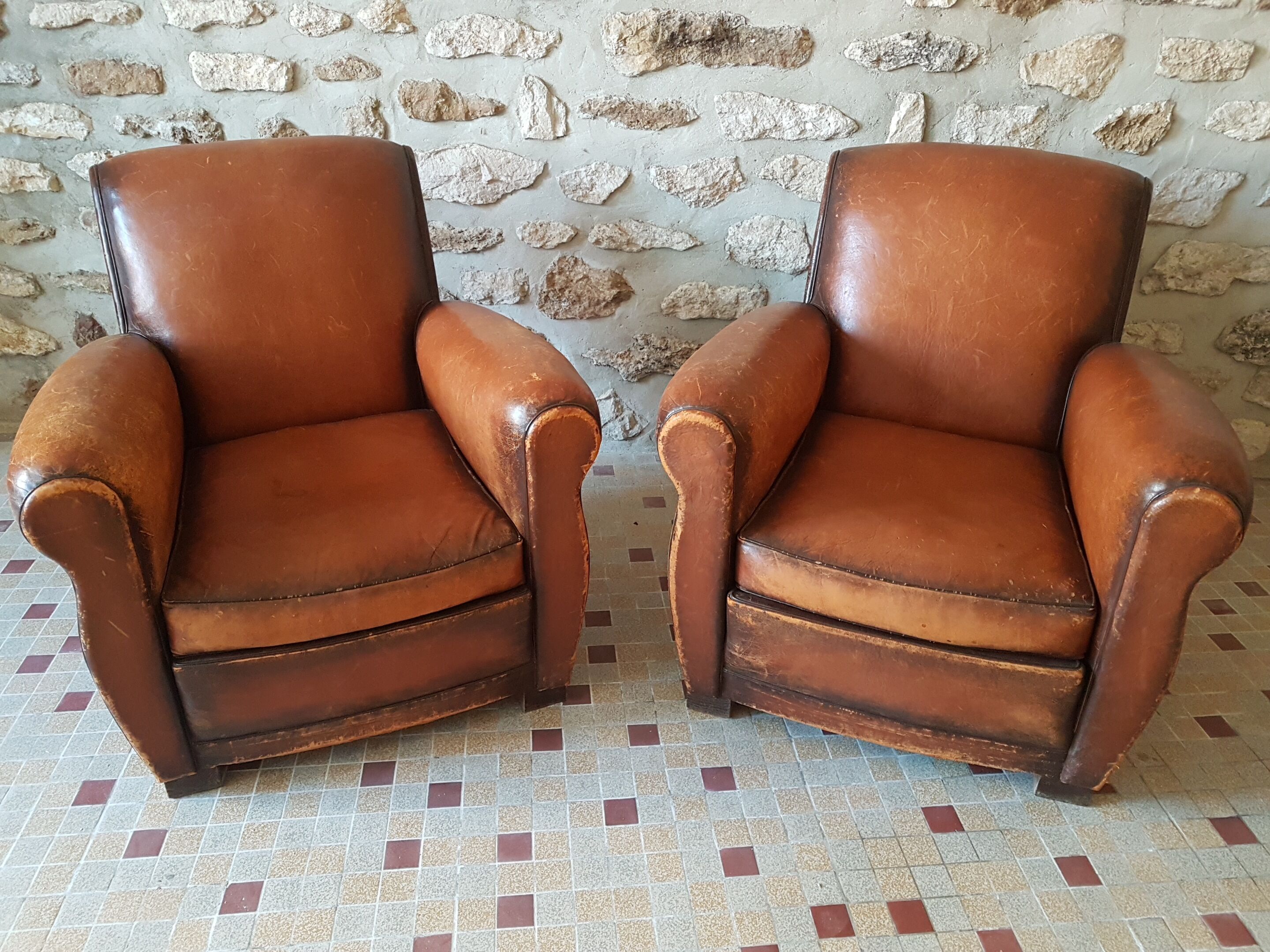 Paire de fauteuil club en cuir cognac patiné et usé