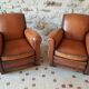 Paire de fauteuil club en cuir cognac patiné et usé