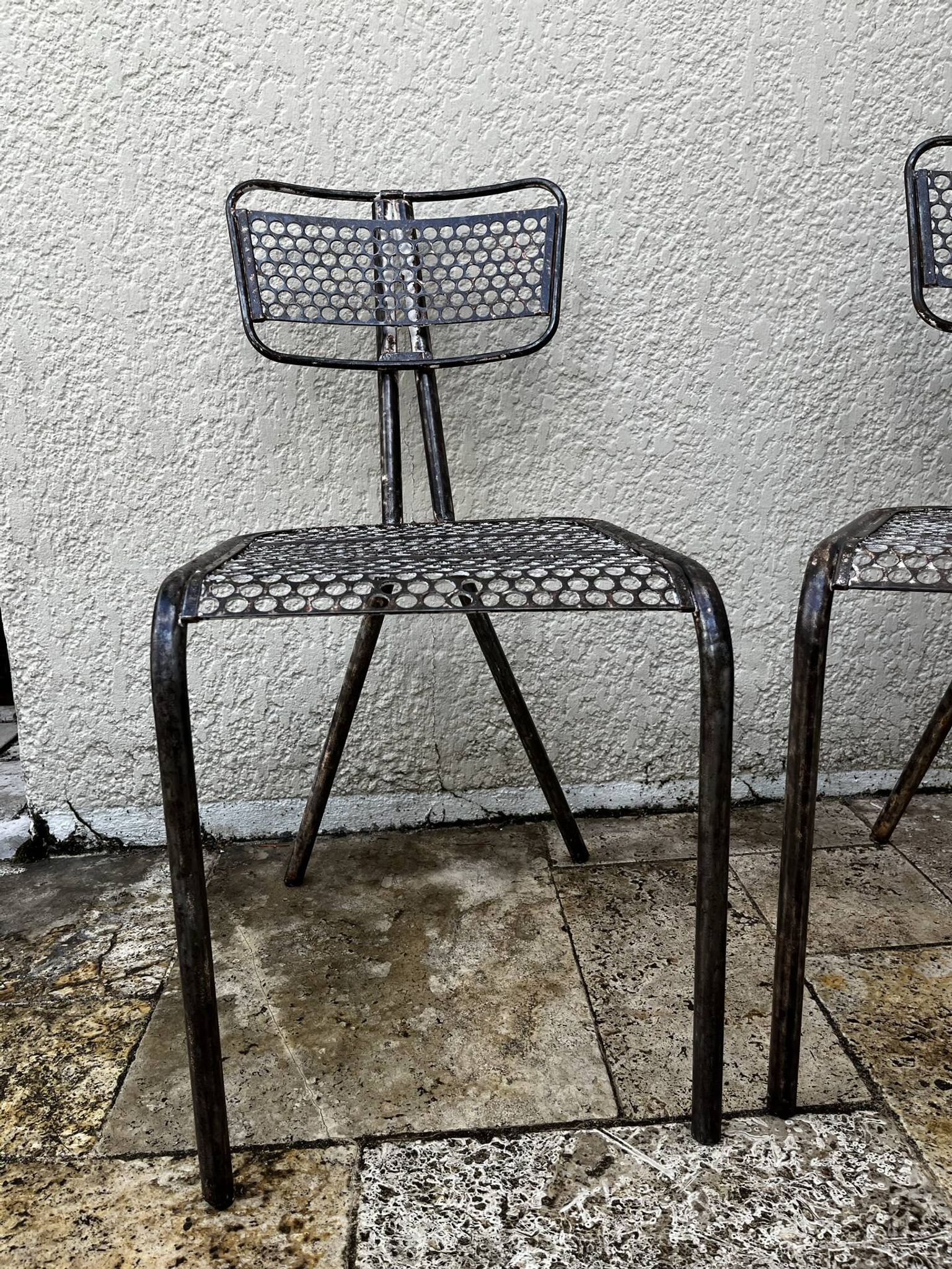 Pairs of perforated metal chairs by René Malaval