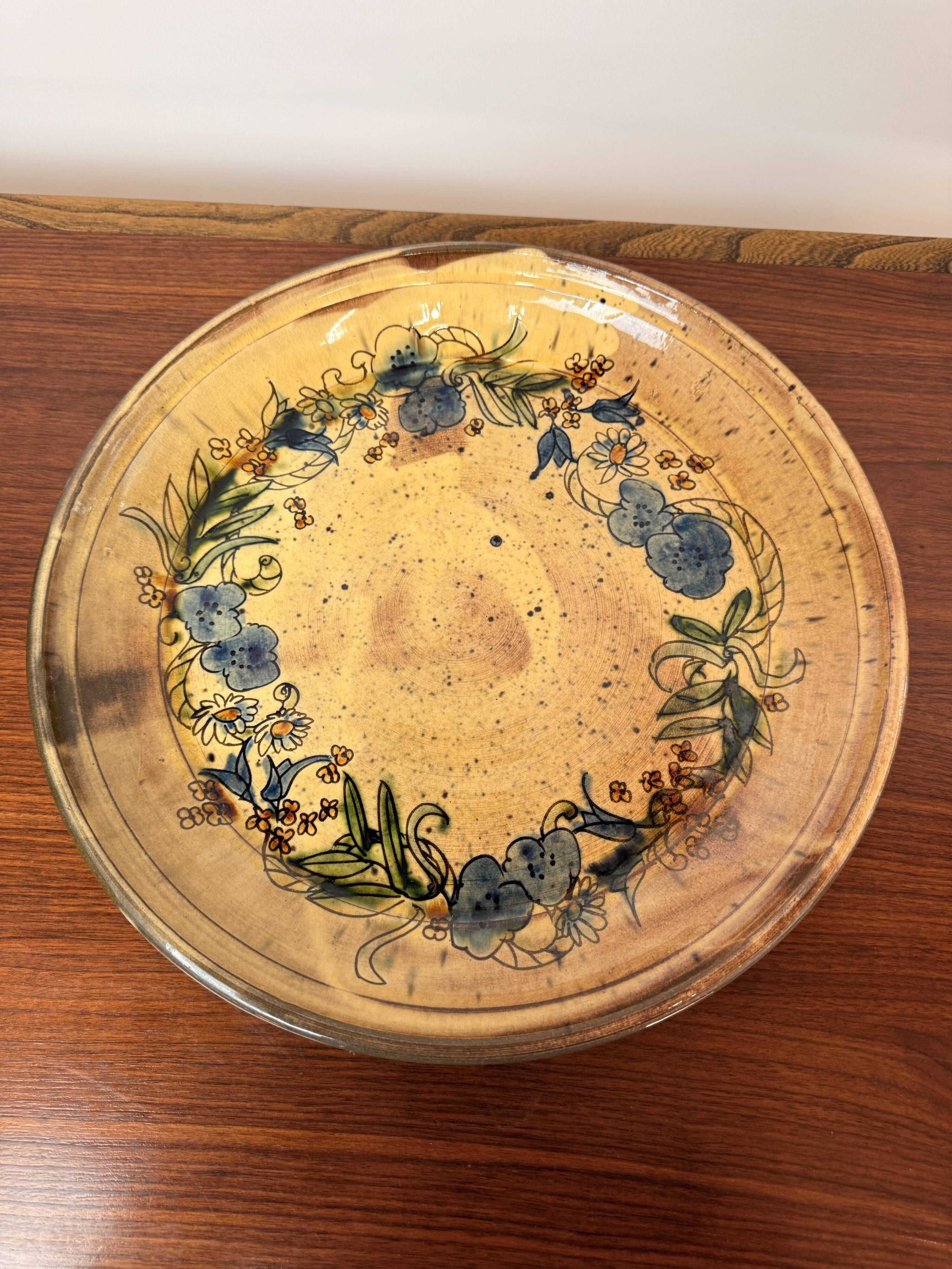 Vintage round ceramic plate with floral decoration.