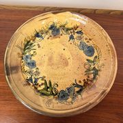 Vintage round ceramic plate with floral decoration.