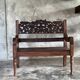Small antique Indonesian bench in carved teak with plant and floral motifs.
