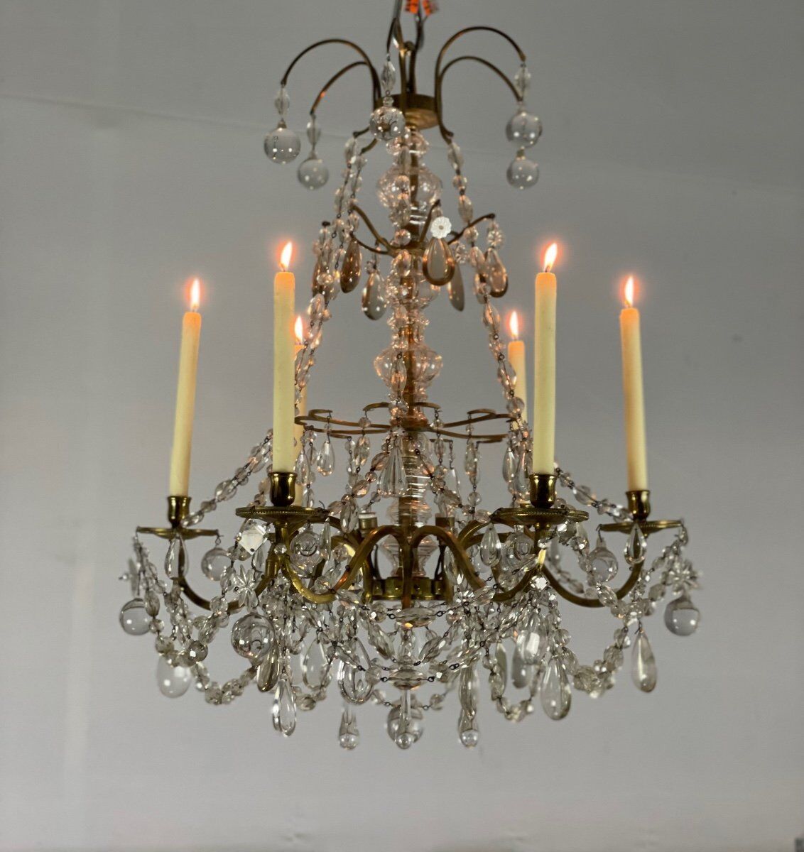 Golden bronze chandelier trimmed with drop-shaped grapevines