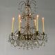 Golden bronze chandelier trimmed with drop-shaped grapevines