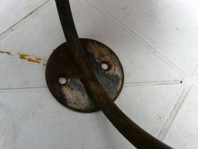 Wall-mounted coat rack with double hooks in metal and wood.