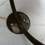 Wall-mounted coat rack with double hooks in metal and wood.