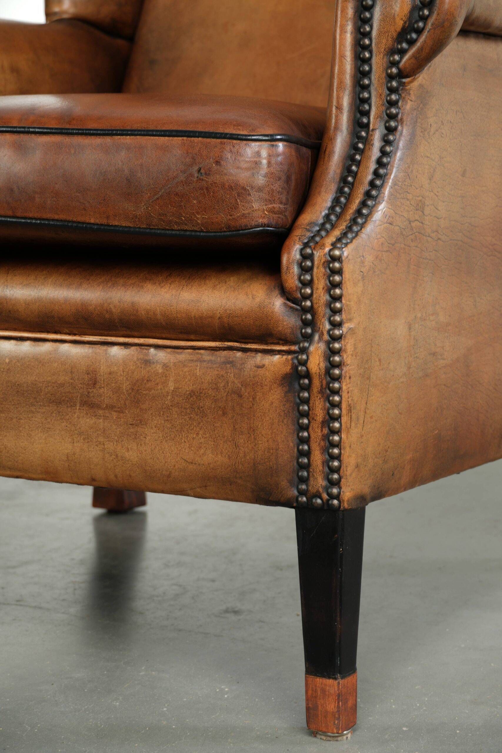 Sheepskin wingback armchair with patina finished with decorative nails
