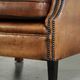 Sheepskin wingback armchair with patina finished with decorative nails