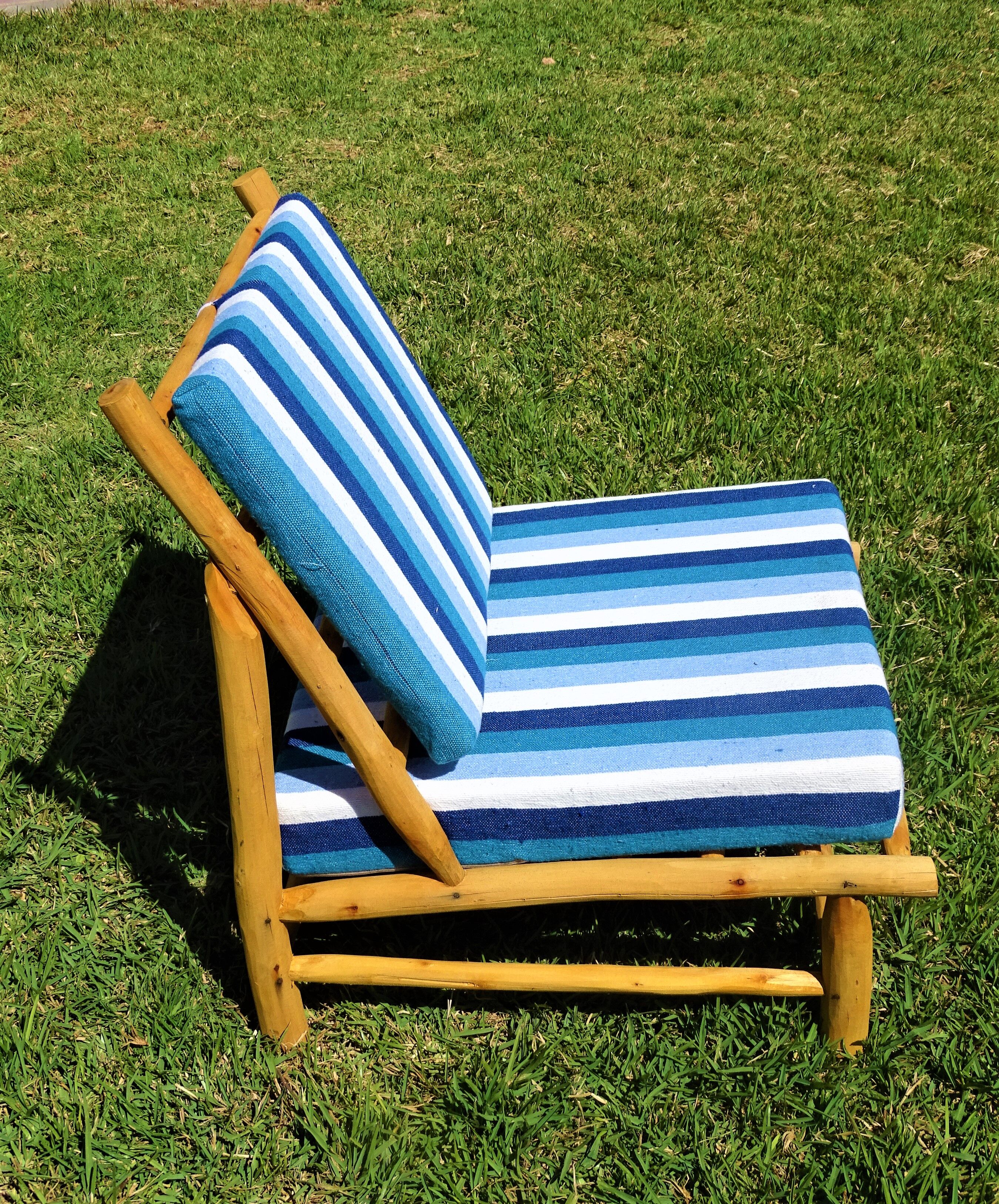 Low armchair in eucalyptus wood with blue and white cushions