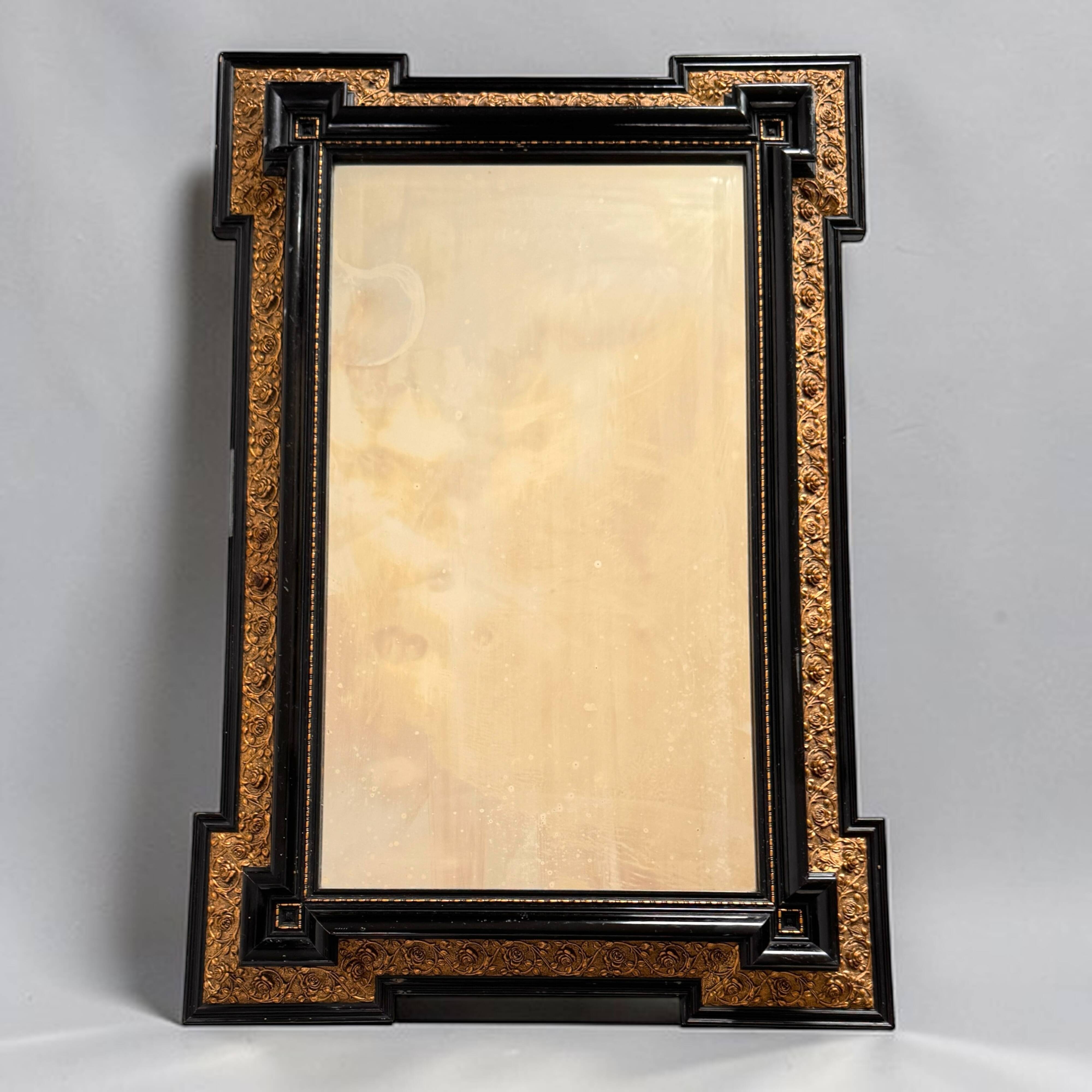 Antique wall mirror in blackened wood and gilded stucco, 19th-century Dutch style.