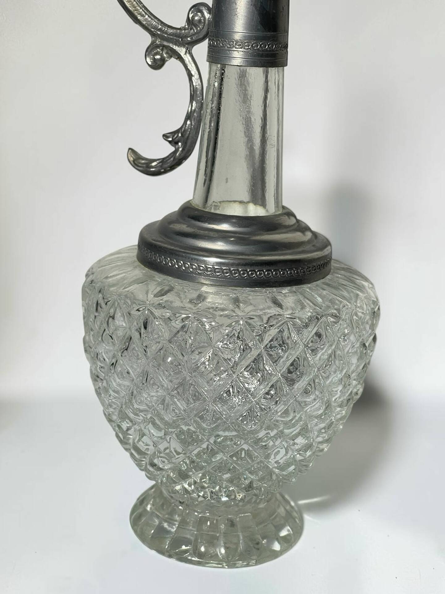 Vintage glass decanter with cut design and silver-plated metal, stopper included.
