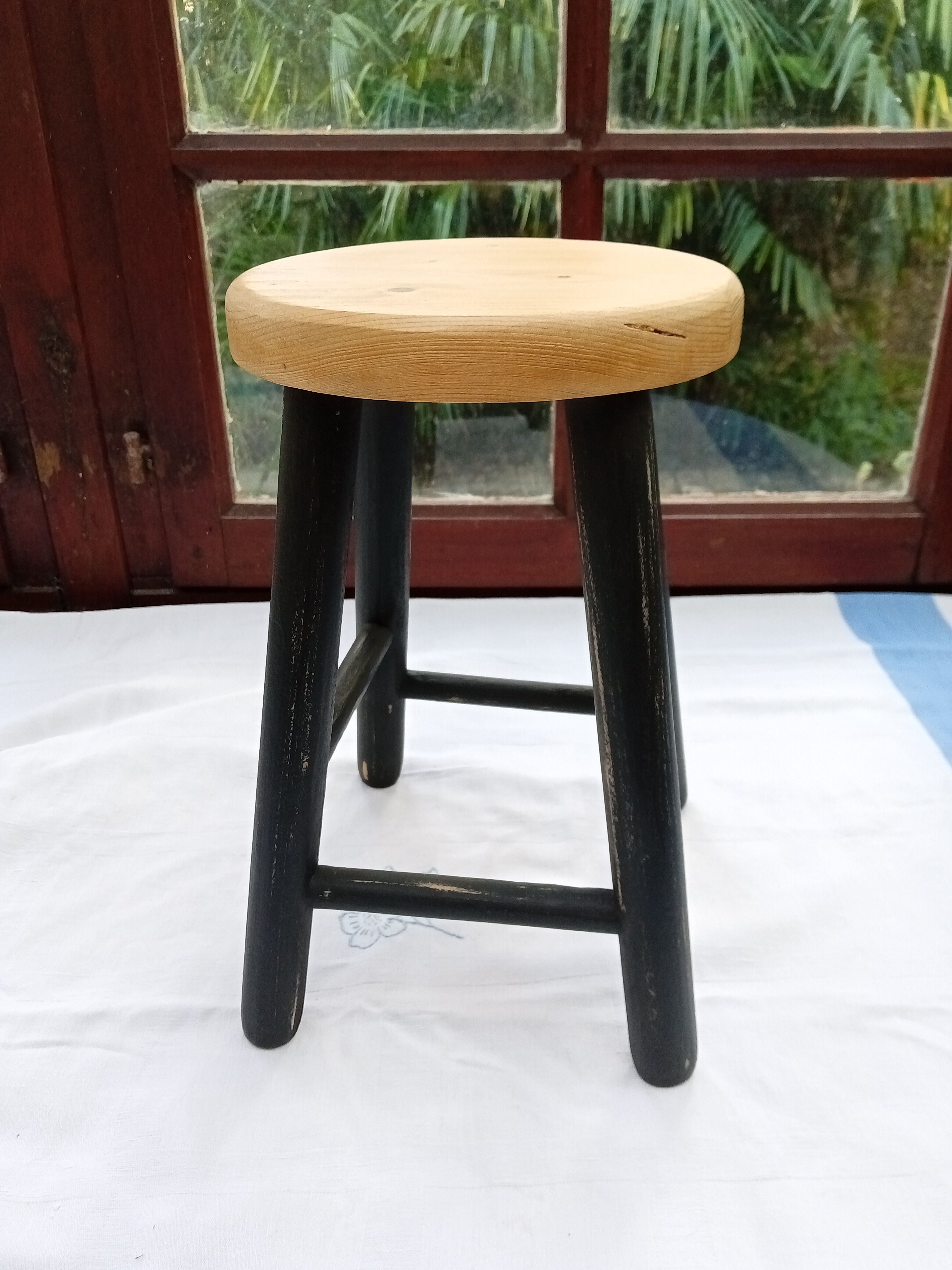 Low wooden stool and black patina