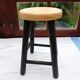 Low wooden stool and black patina