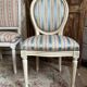 Pair of Louis XVI style chairs in painted wood and satin, classic elegance.