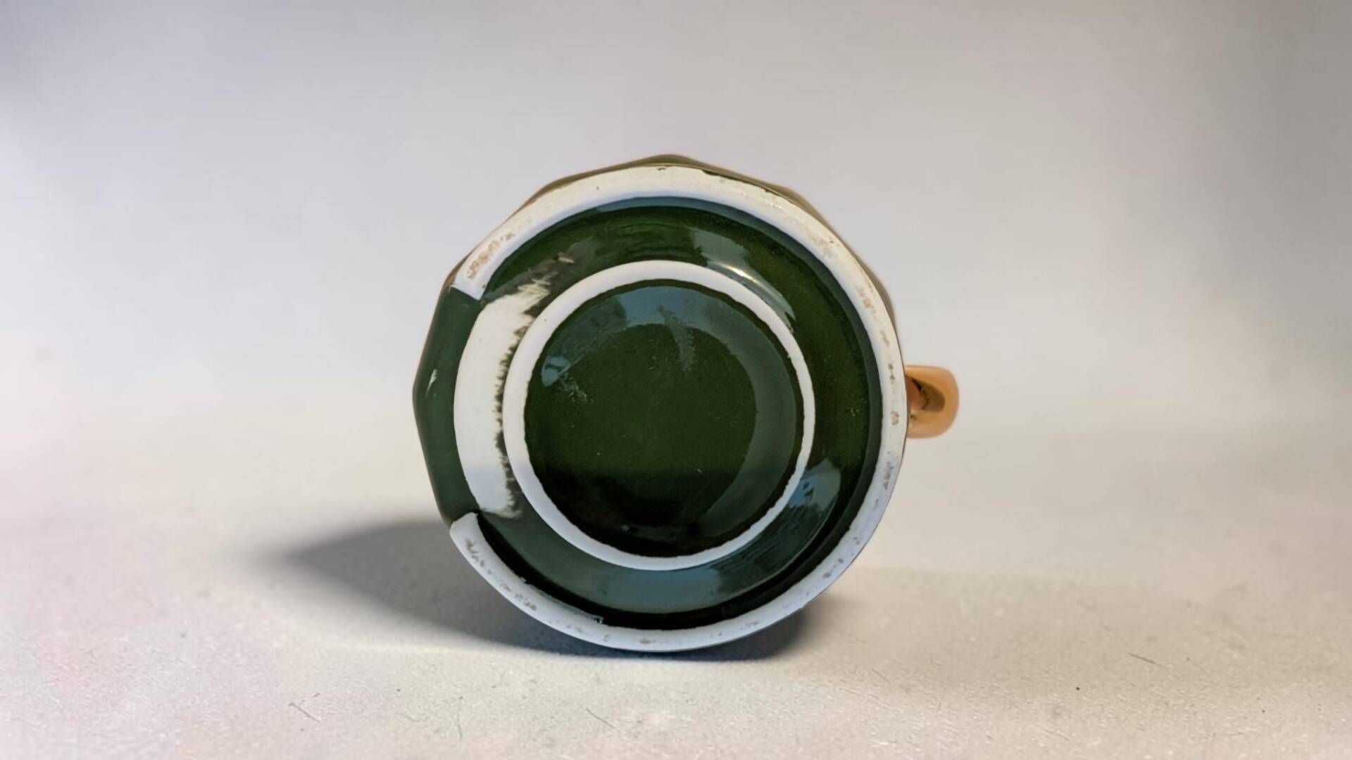 Dark green ceramic decorative jug with golden trim.