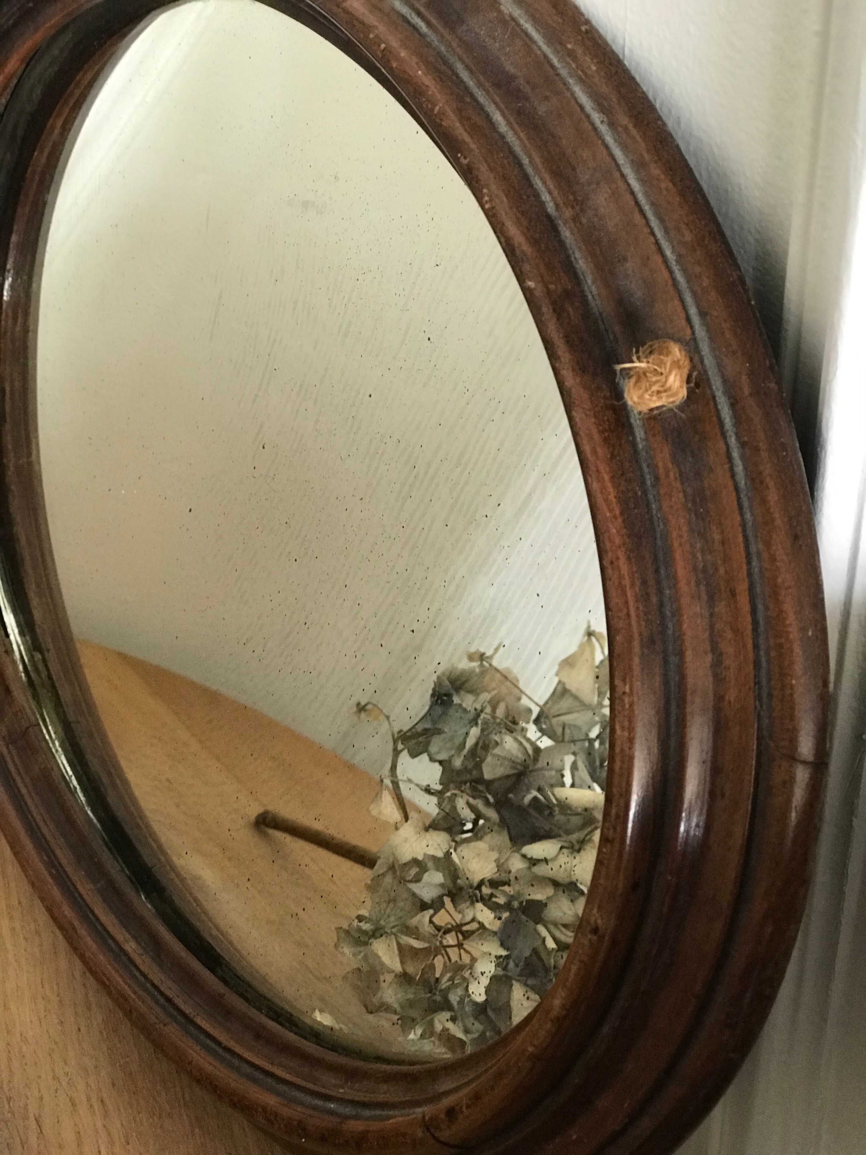 Old oval mirror with wooden frame