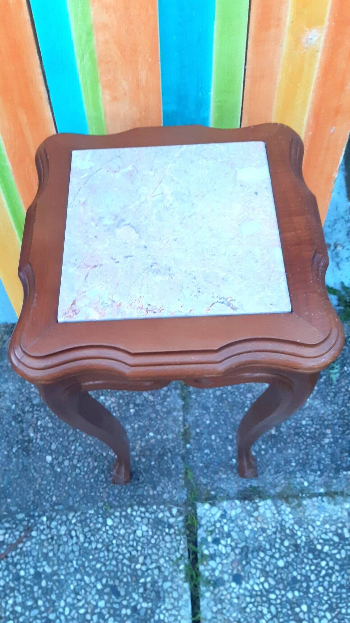 Curved leg wooden stand with a marble top.