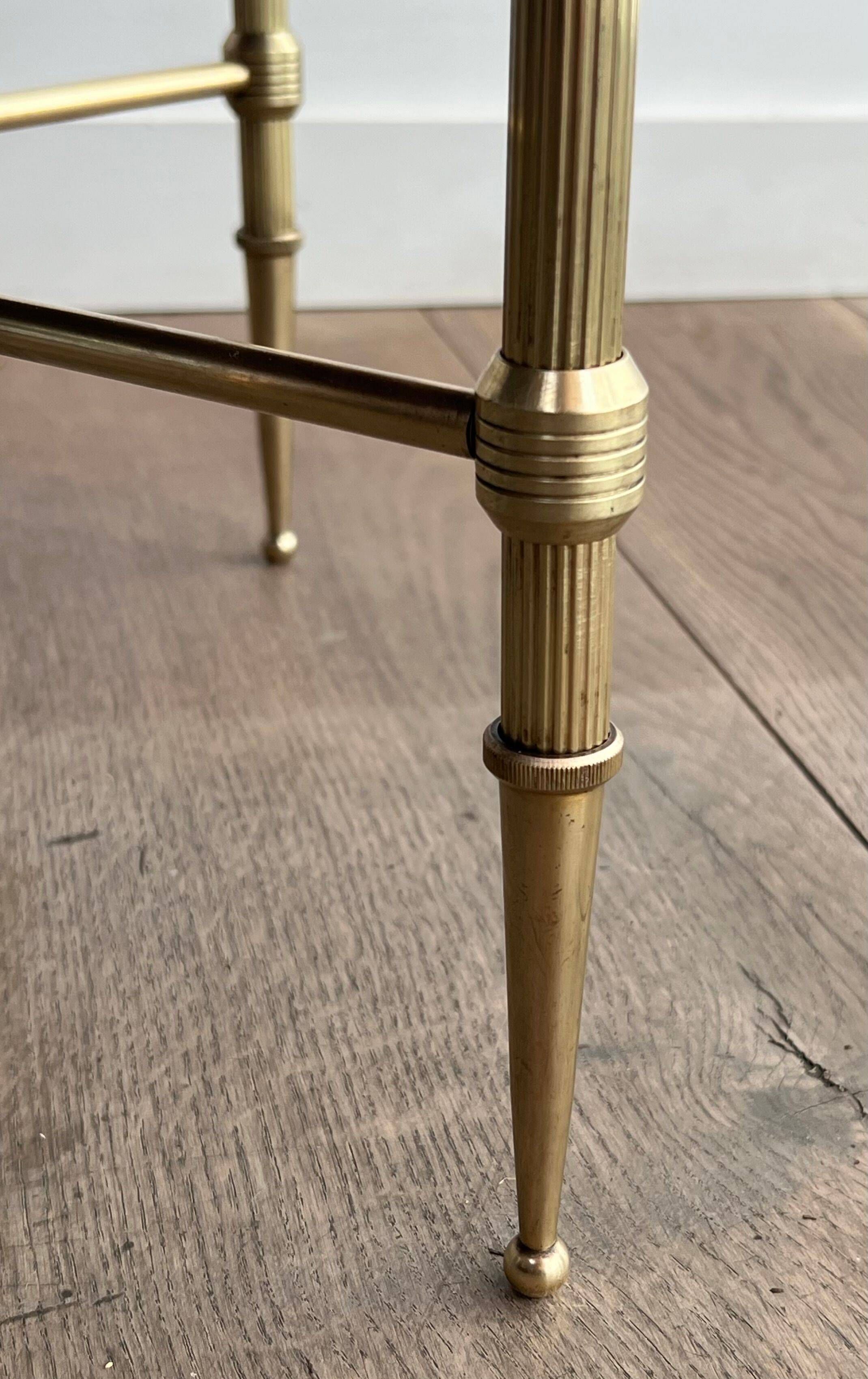 Round coffee table in brass with a black lacquered glass top from Maison Jansen.