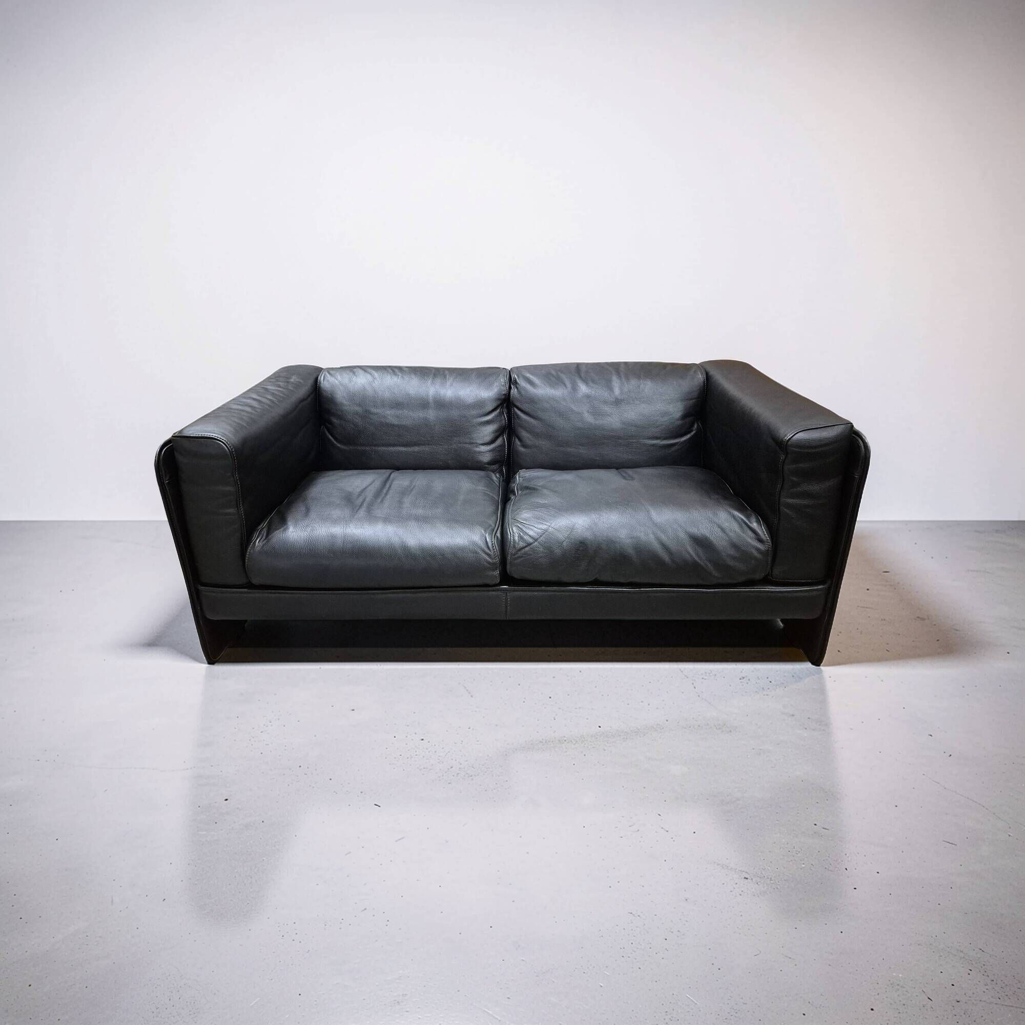 Two-seater sofa in black leather, designed by Tito Agnoli for Poltrona Frau, Italy, 1980s
