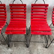 Red slatted chair with a black metal frame.