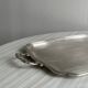 Silver metal serving tray with sculpted handles