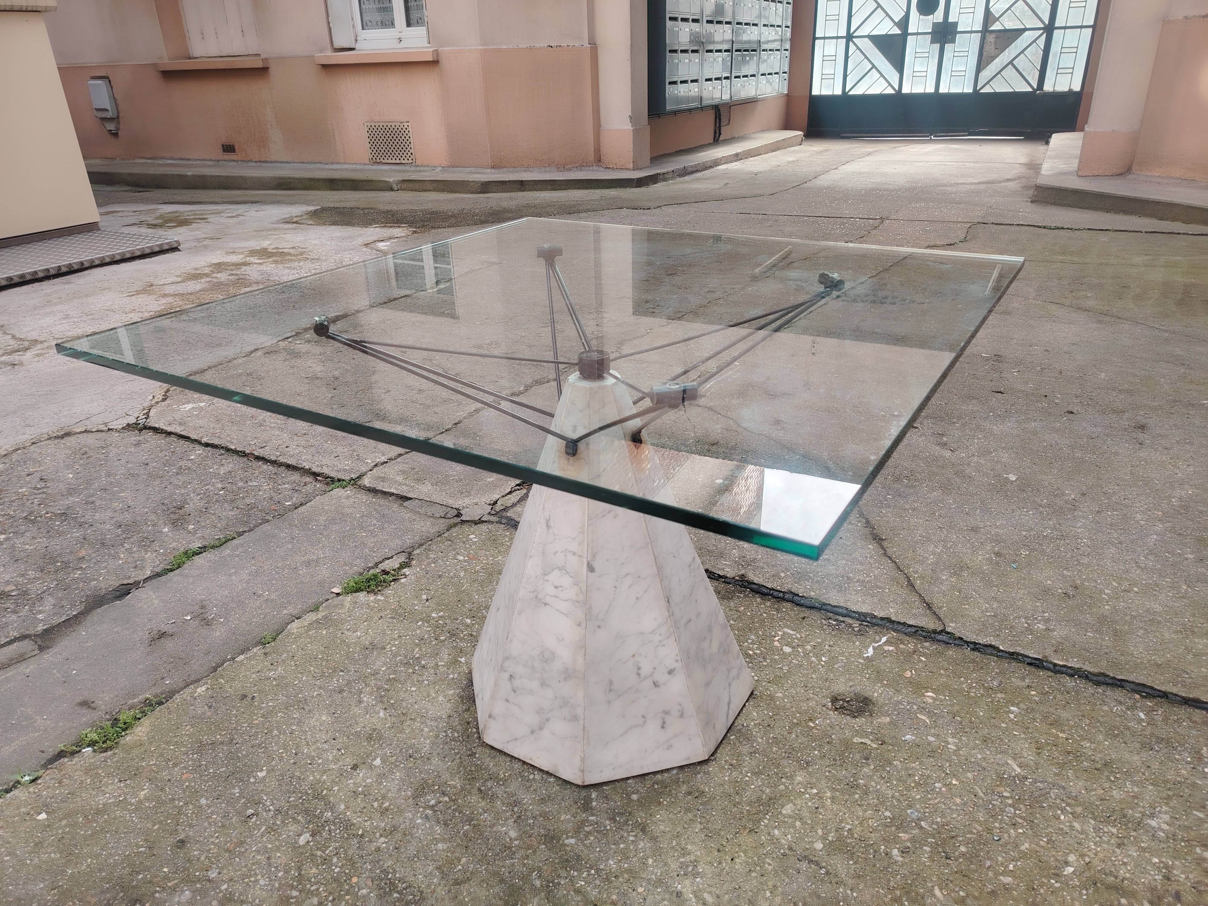 1980s table with a marble and steel base and a square glass top.