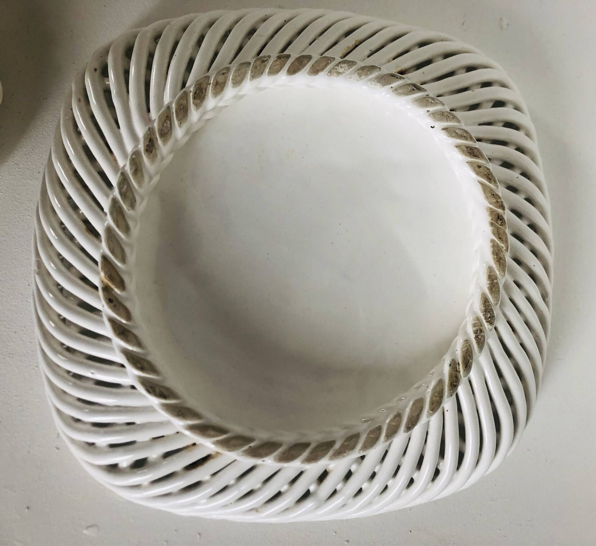 Covered basket in white woven ceramic and fruit slip.